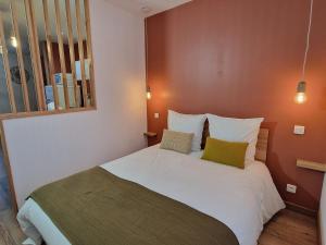 a bedroom with a white bed with two pillows at Studio calme centre-ville Châteauroux avec parking - FR-1-591-725 in Châteauroux
