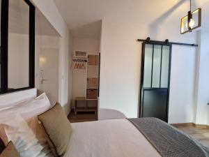 a bedroom with a white bed and a window at Studio moderne et calme au centre-ville avec parking sécurisé - FR-1-591-723 in Châteauroux