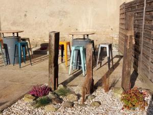 a row of tables and stools next to a wall at Studio calme centre-ville Châteauroux avec parking - FR-1-591-725 in Châteauroux