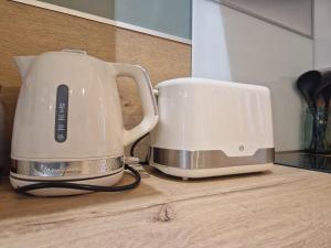 Ein Toaster und eine Kaffeemaschine stehen auf der Küchentheke. in der Unterkunft Studio moderne et calme avec parking à Châteauroux - FR-1-591-724 in Châteauroux