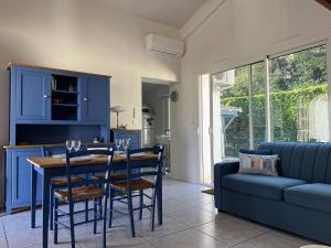 a kitchen with blue cabinets and a table and chairs at Vaux-sur-Mer: Villa 2 chambres pour 5 pers, 450m Plage, Parking, Clim - FR-1-738-47 in Vaux-sur-Mer