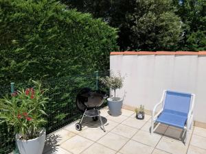 a patio with a grill and a blue chair at Vaux-sur-Mer: Villa 2 chambres pour 5 pers, 450m Plage, Parking, Clim - FR-1-738-47 in Vaux-sur-Mer