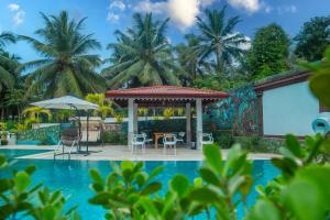 a swimming pool with a gazebo next to a resort at Imbulana Villa & Tea Estate in Ruwanwella