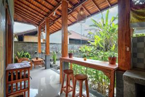 a patio with a bar and stools on a porch at Gami Ubud Villa in Ubud