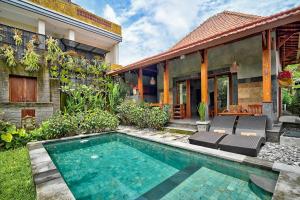 a house with a swimming pool in the yard at Gami Ubud Villa in Ubud