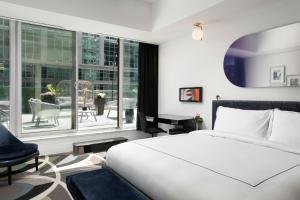 a bedroom with a bed and a large window at BISHA, a Luxury Collection Hotel, Toronto in Toronto