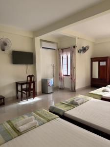 a hotel room with two beds and a television at Thinh Khang Hotel Vung Tau in Vung Tau