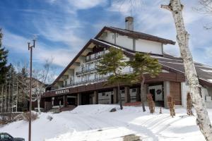 a building with snow in front of it at Madarao Kogen Hotel in Iiyama