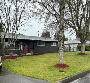 a house with a tree in the front yard at Emerald City 3 Bedroom 1 bath Home in Eugene