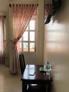 a dining room with a table and a window at Thinh Khang Hotel Vung Tau in Vung Tau
