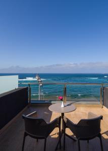 a table and chairs on a balcony with the ocean at Sercotel Playa Canteras in Las Palmas de Gran Canaria