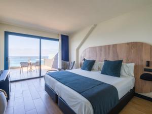 a bedroom with a bed and a view of the ocean at Sercotel Playa Canteras in Las Palmas de Gran Canaria