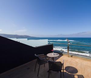 a balcony with a table and chairs and the ocean at Sercotel Playa Canteras in Las Palmas de Gran Canaria