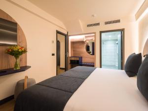 a bedroom with a large white bed in a room at Sercotel Playa Canteras in Las Palmas de Gran Canaria