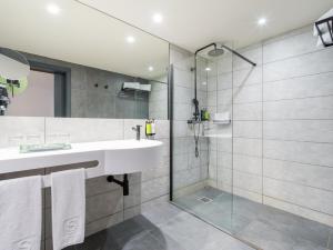 a bathroom with a sink and a shower at Sercotel Playa Canteras in Las Palmas de Gran Canaria