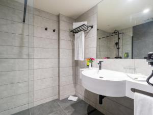 a white bathroom with a sink and a shower at Sercotel Playa Canteras in Las Palmas de Gran Canaria
