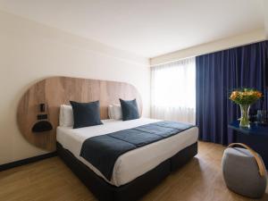 a bedroom with a large bed with a blue blanket at Sercotel Playa Canteras in Las Palmas de Gran Canaria