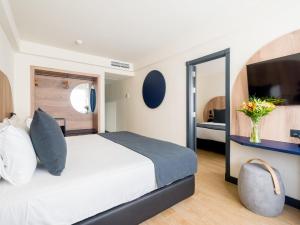 a hotel room with a bed and a mirror at Sercotel Playa Canteras in Las Palmas de Gran Canaria