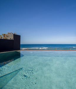 a swimming pool with a view of the ocean at Sercotel Playa Canteras in Las Palmas de Gran Canaria