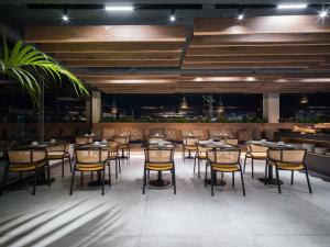a restaurant with tables and chairs and a bar at Sercotel Playa Canteras in Las Palmas de Gran Canaria