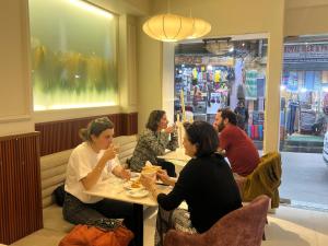 un gruppo di persone seduti a un tavolo in un ristorante di Harsha Boutique Hotel a Kathmandu