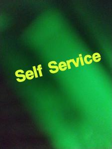 a green sign with the words self service at The Peace Home SRUSHTI AC for Master Bedroom in Kolhapur