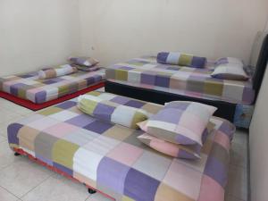three beds sitting in a room with at Villa Ardon Batu in Batu