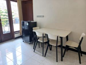 a kitchen with a table and chairs and a refrigerator at Villa Ardon Batu in Batu