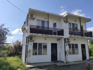 a white house with a balcony on top of it at BlackSeaAp in Kobuleti