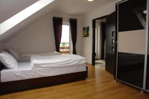 a bedroom with a white bed and a window at JD Apartamenty - Klimatyzacja, basen, parking i wifi w cenie in Mysłakowice