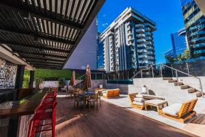 a patio with chairs and tables and a building at Corazón urbano, apartamento Guatemala zona 10 EON in Guatemala