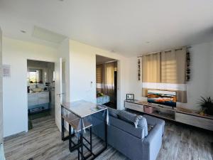 a living room with a couch and a table at Villa Ranitea - maison moderne avec piscine privée in Avae