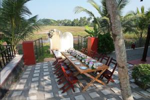 a wooden table with chairs and flowers on it at Nellupura by Tejus in Kumarakom