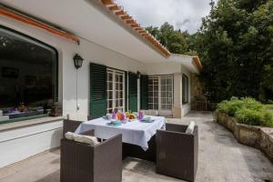 a table with a white table cloth on a patio at ALTIDO Villa Valeverde in Sintra