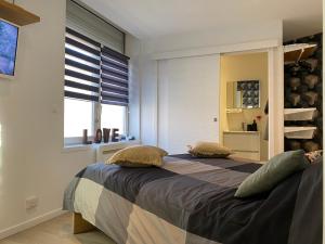 une chambre avec deux lits et une fenêtre dans l'établissement Appartement à découvrir, à Marquette-lès-Lille