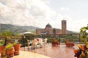 a balcony with a table and chairs and a building at Marge Hotel in Aparecida