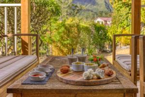 a tray of food on a wooden table on a porch at La Villa Soalic in Cilaos