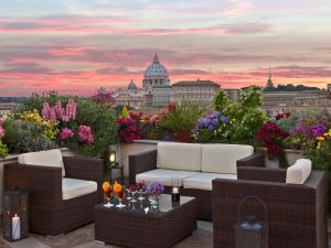 a rooftop patio with a view of a city at Atlante Star Hotel in Rome