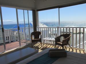 a bedroom with a balcony with a view of the ocean at Point Village Accommodation - Hennie Top in Mossel Bay