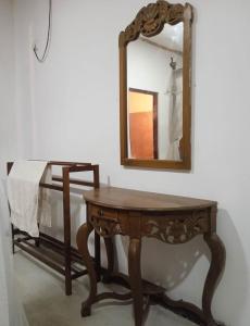a wooden table with a mirror on a wall at Chapel Home Stay in Ahungalla