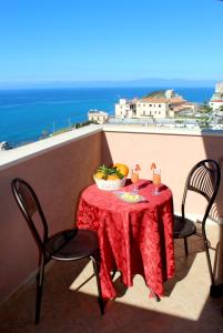 a table on a balcony with a view of the ocean at Hotel Terrazzo Sul Mare in Tropea