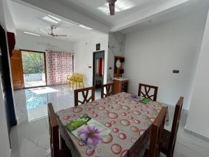 ein Esszimmer mit einem Tisch, auf dem eine Blume steht in der Unterkunft Devas Homestay in Kallar-Bridge