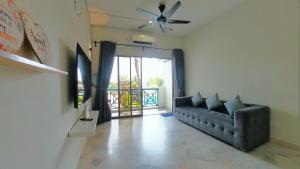 a living room with a couch and a ceiling fan at 1-10pax DoorStep private beach & swimming pool in Port Dickson