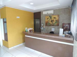 una sala de espera con un mostrador y una pared amarilla en Hotel & Hostel San José en Ribeirão Preto