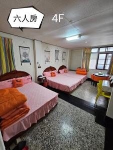 a room with two beds in it with an asian writing on the wall at 環泰大旅社 A go da 單未留電話不接單 本店無電梯 in Shuili