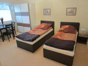 two beds in a room with a table and a dining room at Apartment Erfordia Erfurt am Egapark in Erfurt