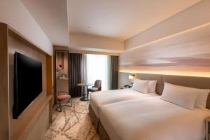 Rúm í herbergi á DoubleTree by Hilton Toyama