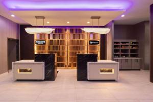 a lobby with two tables and a wall of wine bottles at La Quinta Inn & Suites by Wyndham DeSoto in DeSoto