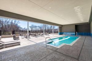 a large swimming pool in a building with a patio at La Quinta Inn & Suites by Wyndham DeSoto in DeSoto