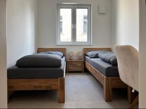 two beds in a room with a window at Oldenburg City Apartments in Oldenburg